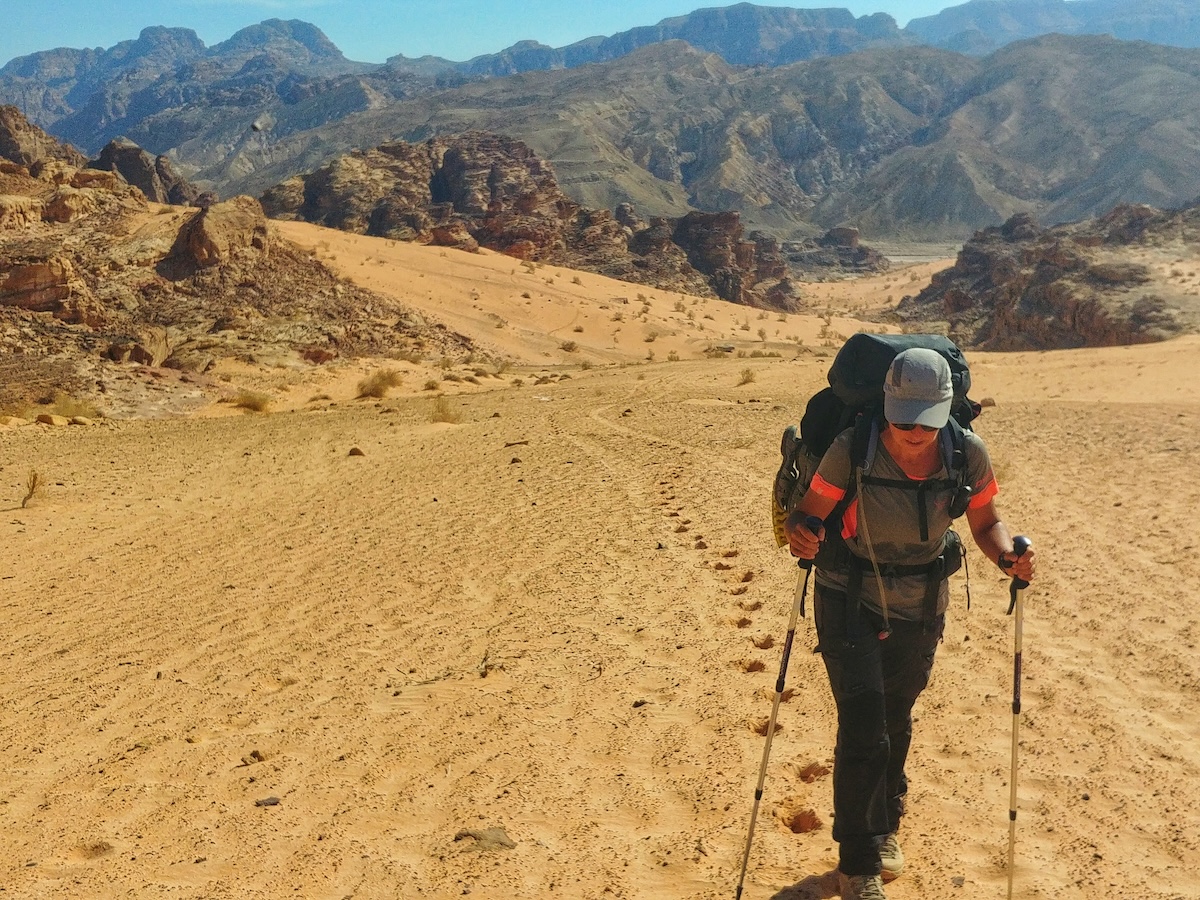 Marco con lo zaino in spalla nel deserto di sabbia durante il Jordan Trail in Giordania