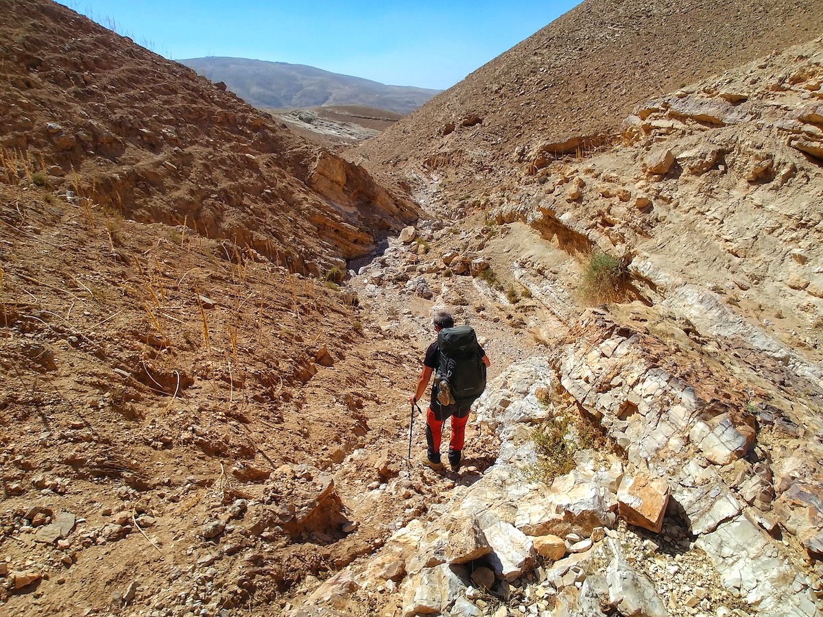 Marco cammina su un sentiero di montagna durante la traversata del Jordan Trail in Giordania