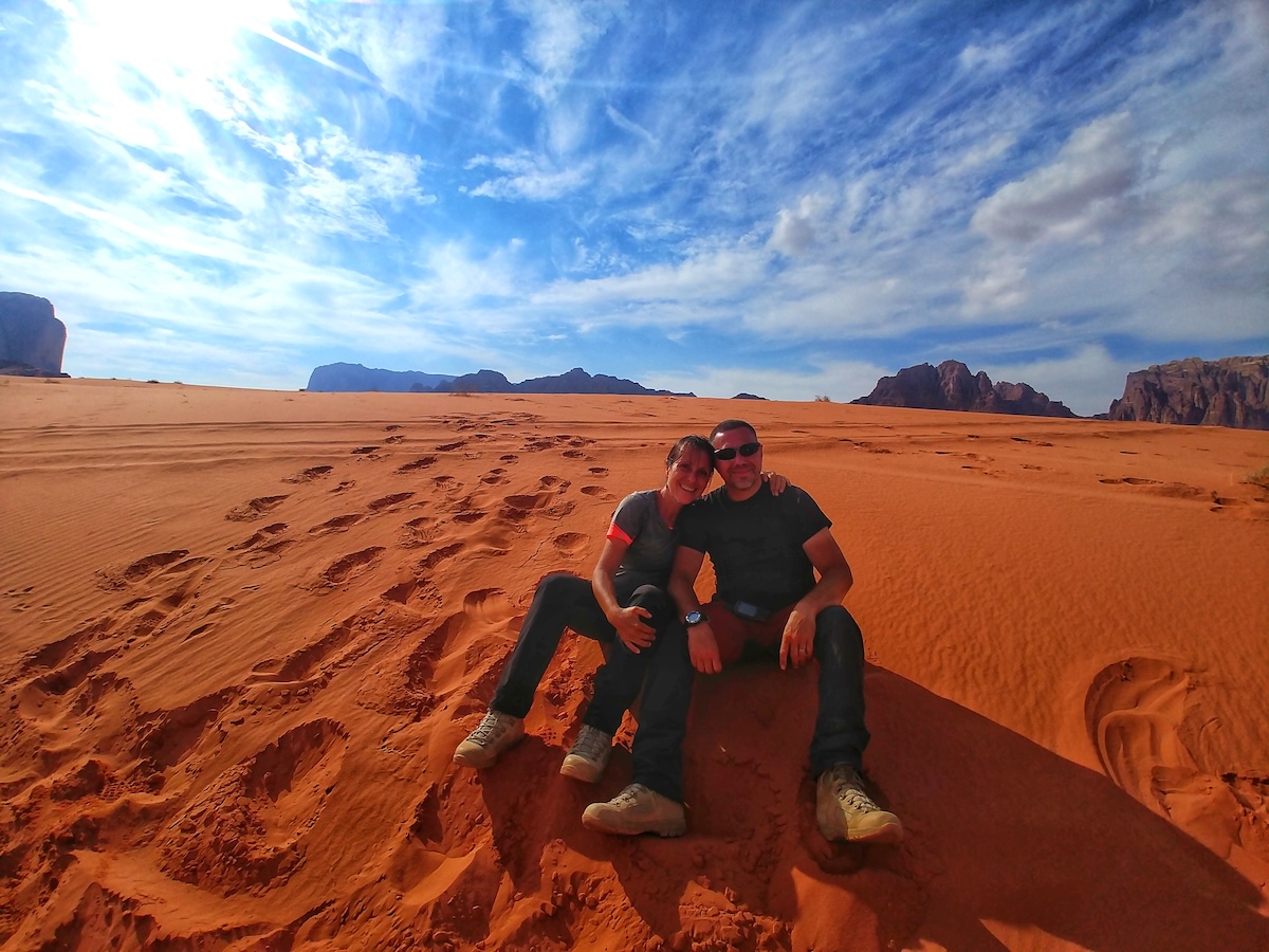 Escursionista seduto sulle dune rosse del deserto di Wadi Rum